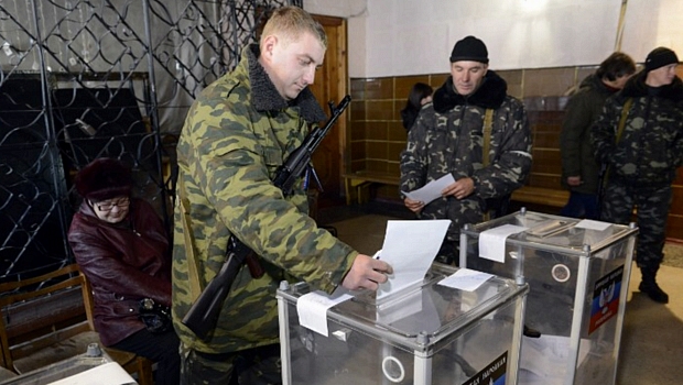 Combatente pró-russo deposita voto em urna na região de Donetsk