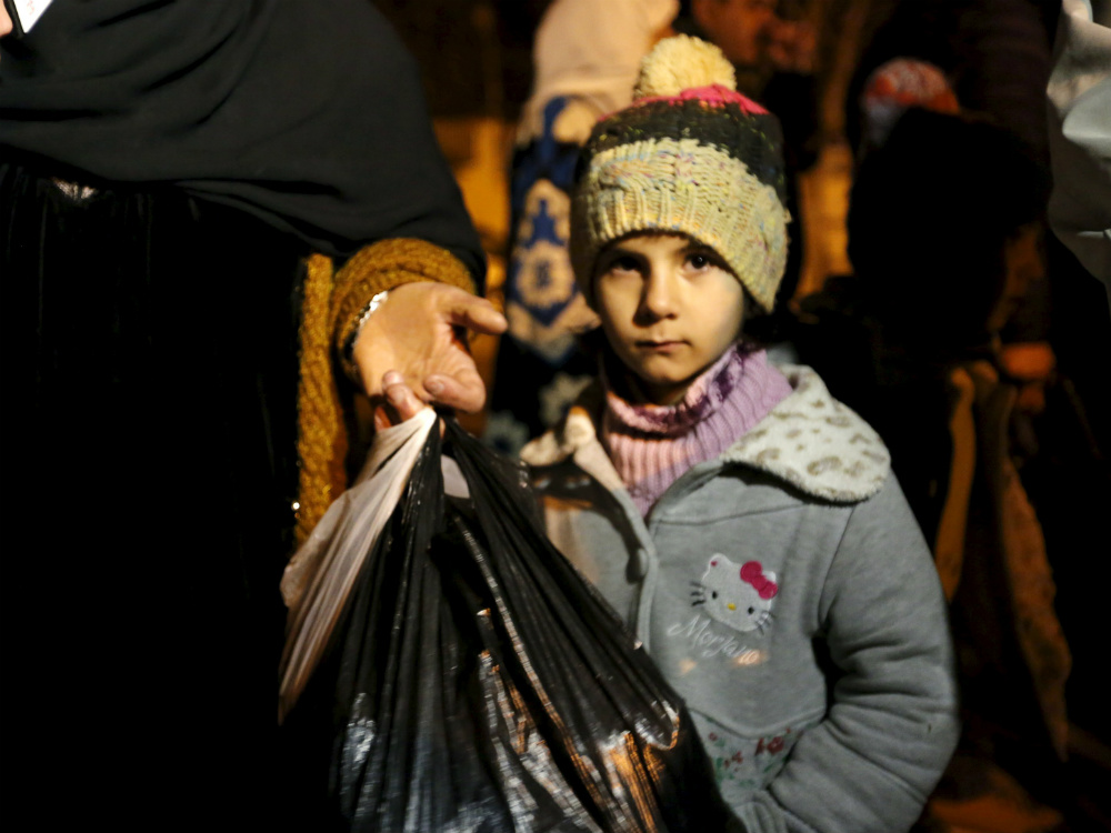 Garota síria aguarda na fila para ser retirada da cidade de Madaya, que sofre com a fome extrema
