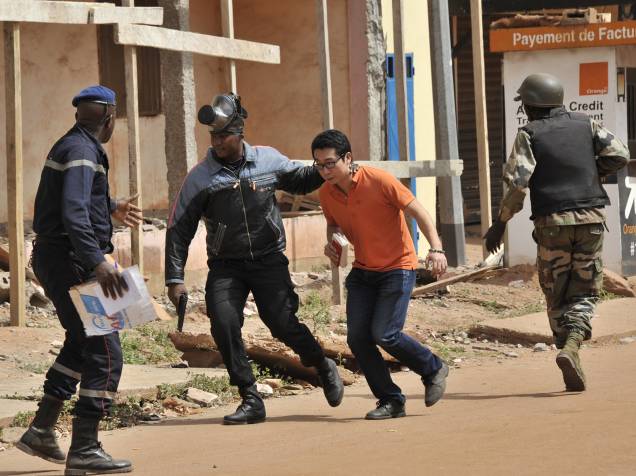 Forças de segurança evacuam um homem da área próxima ao hotel Radisson Blu, em Bamako, Mali