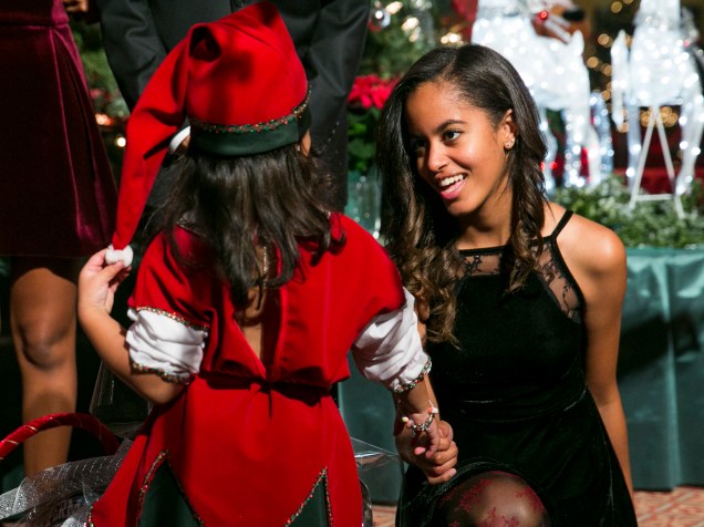 Malia Obama cumprimenta um dos duendes de natal em evento beneficente na Casa Branca, em dezembro de 2014