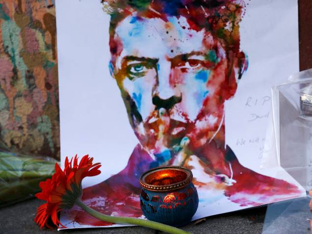Ingleses deixam flores em frente a uma famosa pintura de David Bowie em Londres, nesta segunda-feira (11)