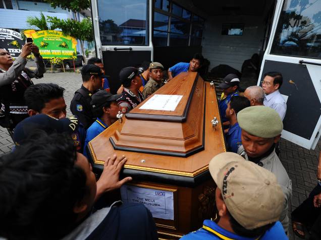 Homens carregam o caixão uma das vítimas do acidente de com o voo QZ8501 da AirAsia em Surabaya, na Indonésia - 03/01/2015