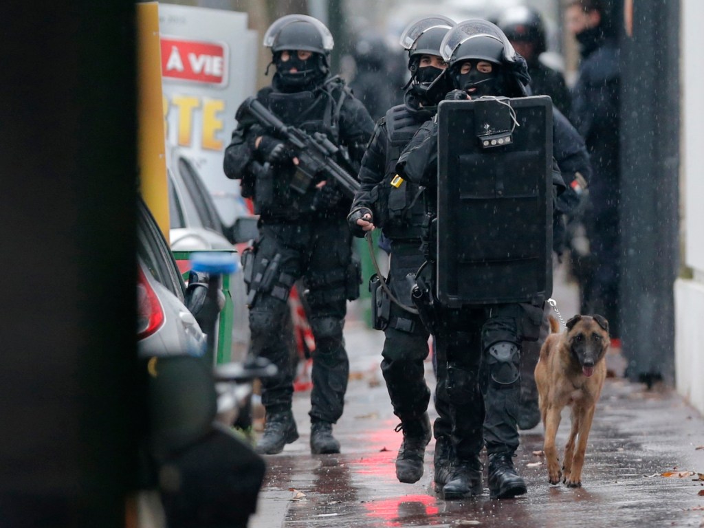 Membros da polícia francesas caminham com um cão farejador na cena de um tiroteio na rua de Montrouge, nos arredores de Paris, no local onde um policial foi morto nesta quinta-feira - 08/01/2015