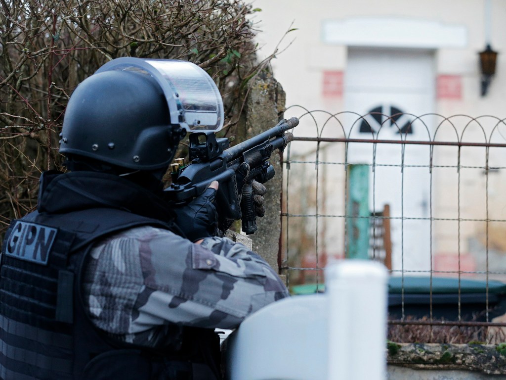 Membro da polícia francesa anti-terrorismo patrulha uma área em Corcy, a nordeste de Paris, onde os suspeitos do ataque à revista 'Charlie Hebdo' foram vistos após roubar um posto de gasolina - 08/01/2015
