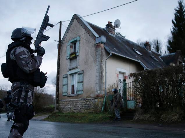Membros da polícia francesa anti-terrorismo patrulham uma área em Corcy, a nordeste de Paris, onde os suspeitos do ataque à revista Charlie Hebdo foram vistos após roubar um posto de gasolina - 08/01/2015