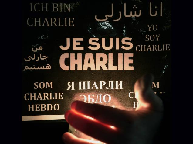 Mulher segura uma vela e um cartaz com a frase Eu sou Charlie em diversas línguas, durante uma manifestação em Estrasburgo, no leste da França - 08/01/2015