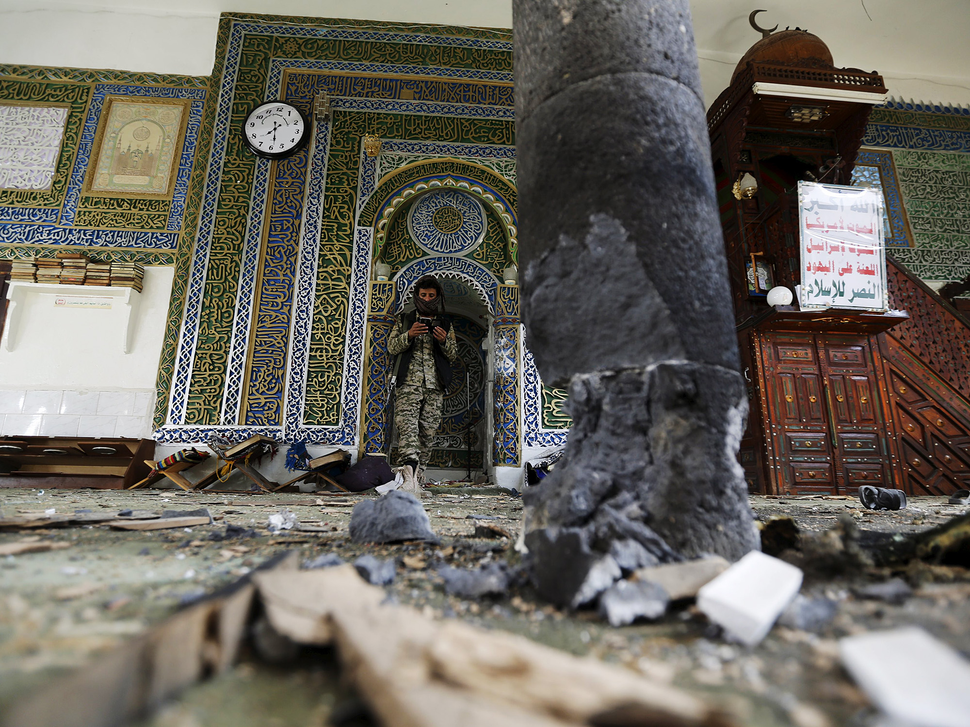 Militante Houthi caminho no interior da mesquita al-Balili, parcialmente destruída após dois atentados a bomba no local, em Sanaa, Iêmen - 24/09/2015