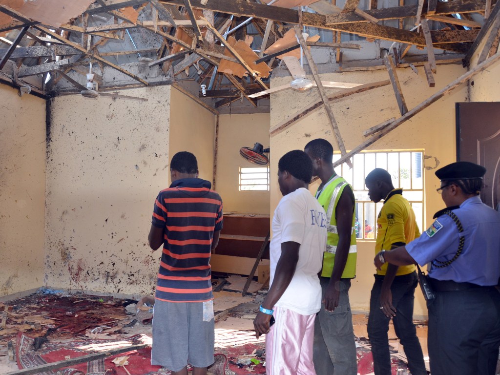 Pessoas observam a destruição provocada por atentado suicida em uma mesquita na cidade de Maiduguri, nordeste da Nigéria, ao menos 15 pessoas morreram - 23/10/2015