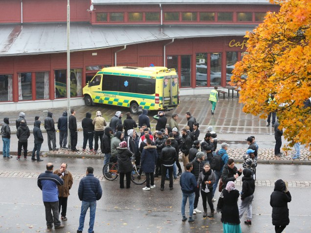 Populares se concentram nos arredores de uma escola em Trollhättan, na Suécia após o ataque de um homem mascarado armado com uma espada - 22/10/2015