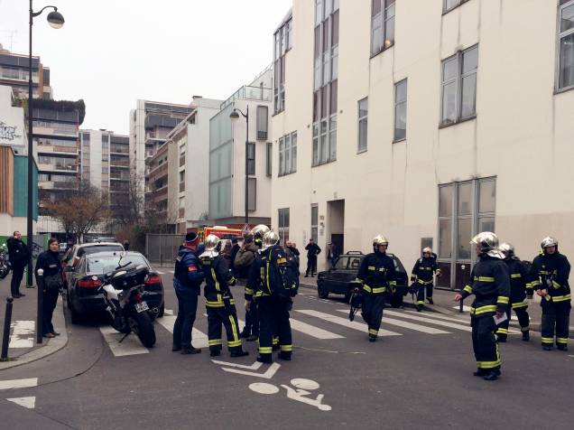 Policiais e bombeiros se reúnem em frente aos escritórios do jornal satírico francês Charlie Hebdo em Paris, depois de homens armados terem invadido o local - 07/01/2015