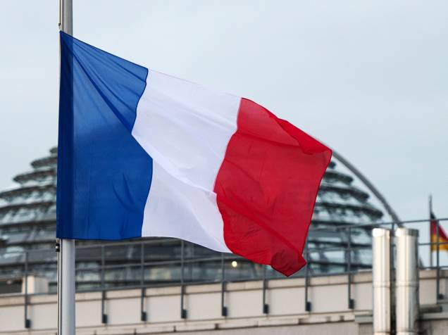 A Bandeira da França fica a meio-mastro, em Berlim, depois que homens armados invadiram os escritórios da revista francesa Charlie Hebdo, em Paris. Pelo menos 12 pessoas morreram durante o ataque