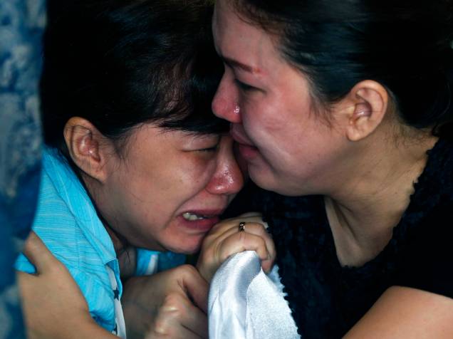 Familiares de passageiros a bordo do avião desaparecido QZ8501 da AirAsia esperam por notícias no Aeroporto Internacional de Juranda, em Surabaya, na Indonésia