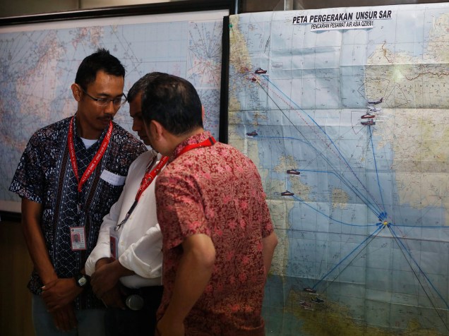 Diretores executivo da Air Asia e da Indonesia Air Asia conversam em frente a mapa para tentar encontrar o avião desaparecido na região de Surabaia, na Indonésia
