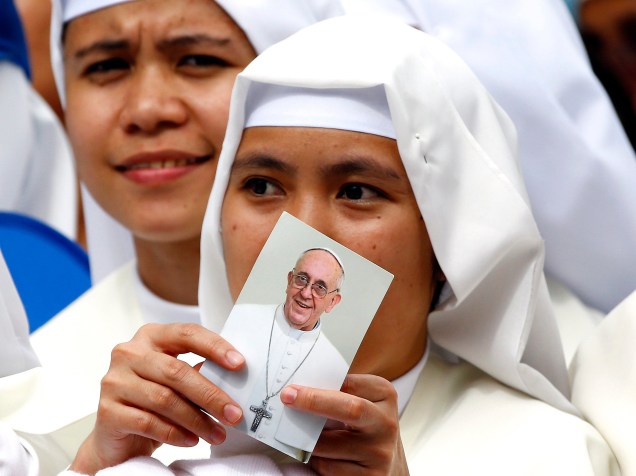 Freira segura uma foto do papa Francisco antes da missa presidida pelo líder da Igreja Católica na Catedral de Manila, nas Filipinas - 16/01/2015