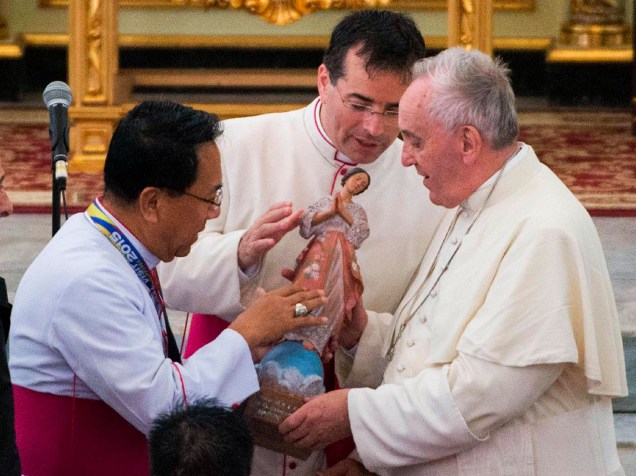 Na Catedral Palo, em Tacloban, Papa Francisco segura estátua junto à membros clérigos locais durante visita ao Sri Lanks e às Filipinas - 17/01/2015