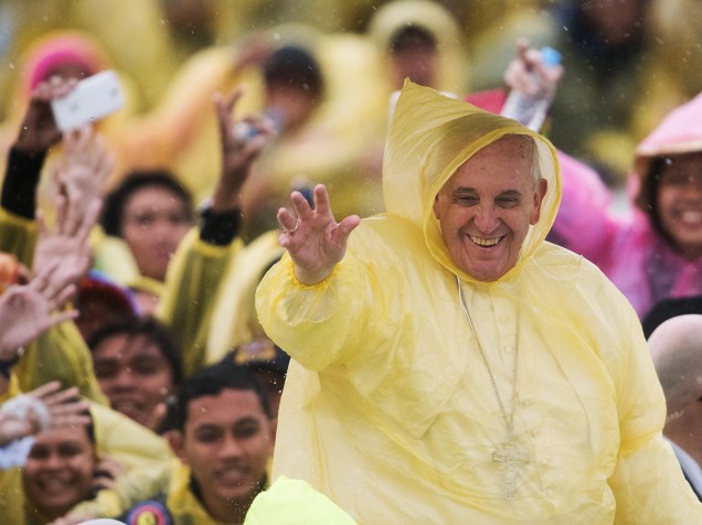 Papa Francisco usa capa de chuva de plástico enquanto acena para fieis na cidade de Tacloban, nas Filipinas