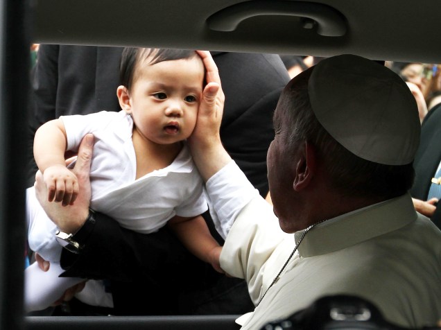 Papa Francisco toca o rosto de um bebê no aeroporto da cidade de Manila, capital das Filipinas - 17/01/2015