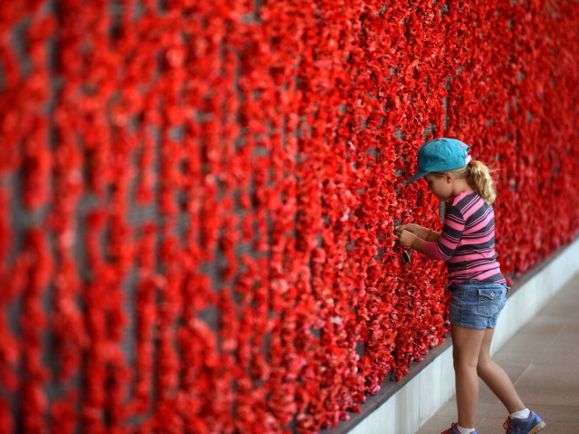 Menina coloca papoulas no Memorial da Guerra, em Camberra, na Austrália, durante a comemoração do Dia da Memória para aqueles que morreram em combate na I Guerra Mundial - 11/11/2014