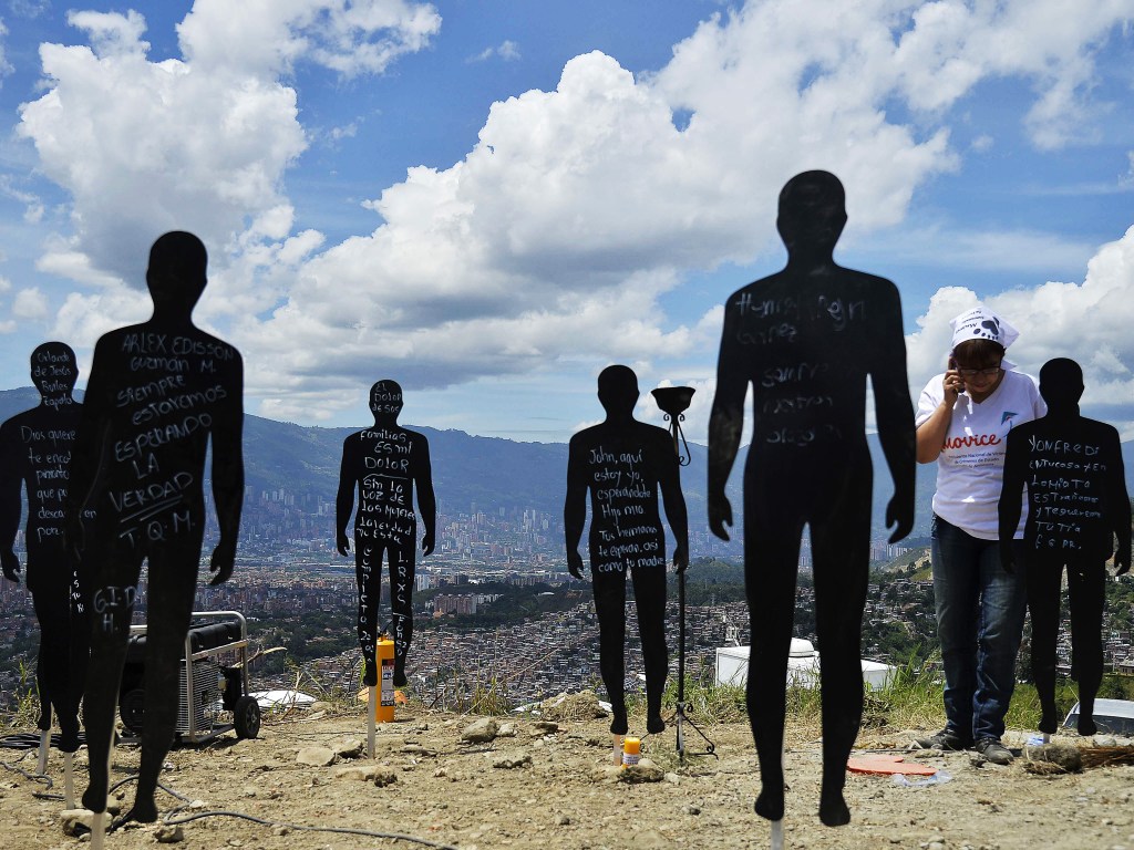 Parentes de pessoas desaparecidas, vítimas da violência, participam de uma cerimônia no lixão "La Escombrera" na favela Comuna 13, em Medellín, na Colômbia - 27/07/2015