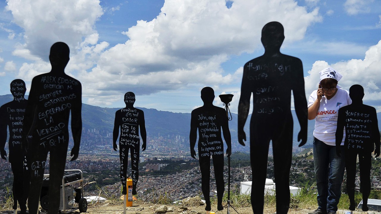 Parentes de pessoas desaparecidas, vítimas da violência, participam de uma cerimônia no lixão "La Escombrera" na favela Comuna 13, em Medellín, na Colômbia - 27/07/2015