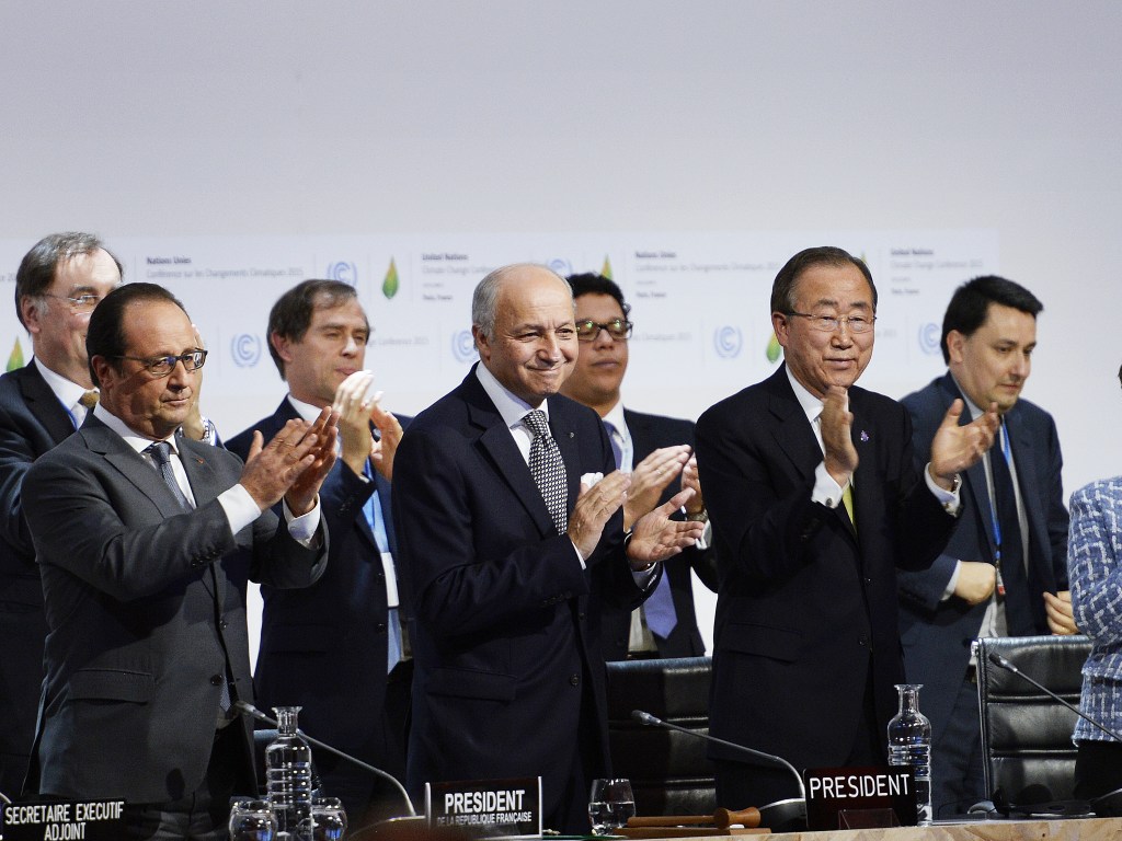 O presidente da França, François Hollande, o chanceler francês, Laurent Fabius e o secretário-geral da ONU, Ban Ki-Moon, aplaudem após anúncio da proposta final da Conferência do Clima (COP21) em Le Bourget, norte de Paris - 12/11/2015