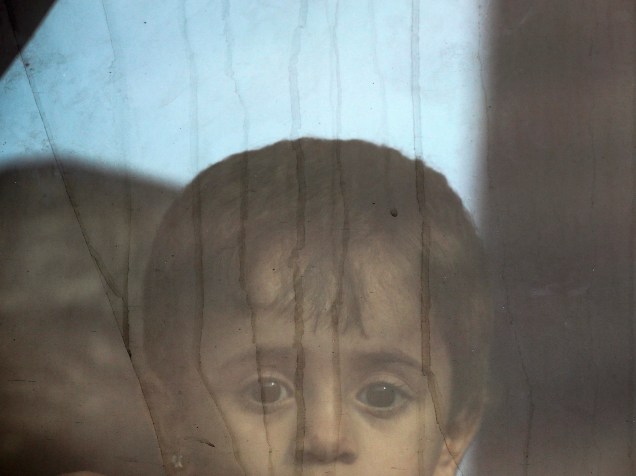 Menina síria olha da janela de um ônibus com refugiados na fronteira da Grécia com a Macedônia, perto da aldeia grega de Idomeni - 08/09/2015