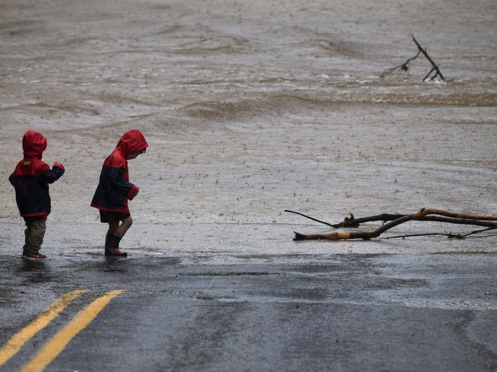 Crianças observam um trecho de estrada inundado após uma forte chuva em Austin, Texas (EUA) - 24/10/2015