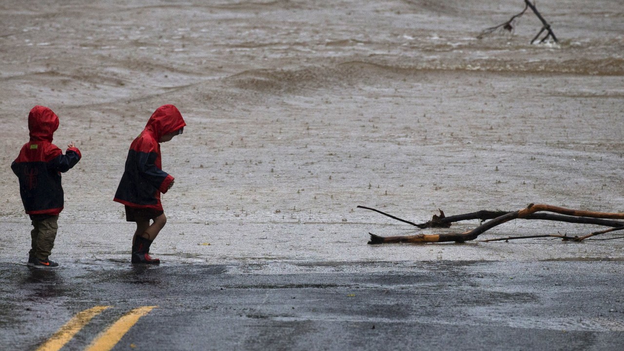Crianças observam um trecho de estrada inundado após uma forte chuva em Austin, Texas (EUA) - 24/10/2015
