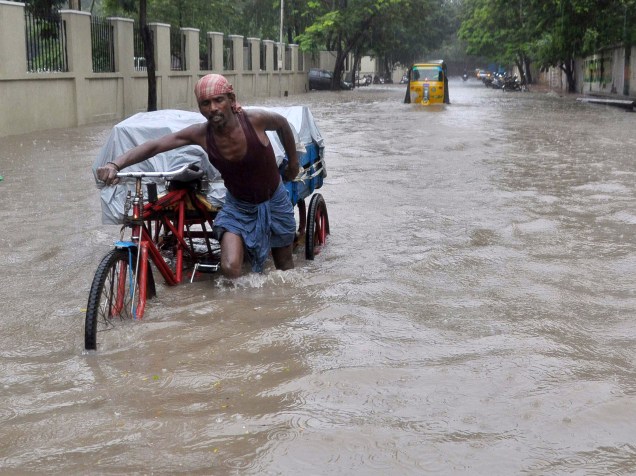 Homem empurra sua bicicleta em meio a uma rua inundada na cidade de Chennai, no estado de Tamil Nadu, sul da Índia - 01/12/2015