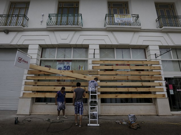 Homens colocam placas de madeira nas janelas de uma loja enquanto o furacão Patricia se aproxima de Puerto Vallarta, no México - 23/10/2015