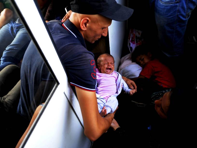 Imigrante sírio segura seu filho de apenas 30 dias em um trem superlotado enquanto viaja pela Macedônia. Milhares de imigrantes do Oriente Médio e da África, têm usado o país como rota para chegar à Europa Ocidental - 02/08/2015