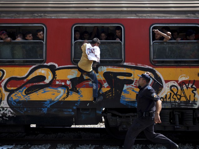 Policial tenta impedir o embarque de um imigrante em um trem na estação de Gevgelija, Macedônia - 15/08/2015