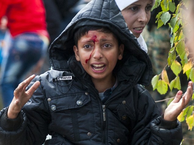 Menino chora depois de ser ferido durante confrontos entre as forças policiais macedônias e imigrantes que tentavam atravessar a fronteira com a Grécia perto da cidade de Gevgelija - 22/08/2015