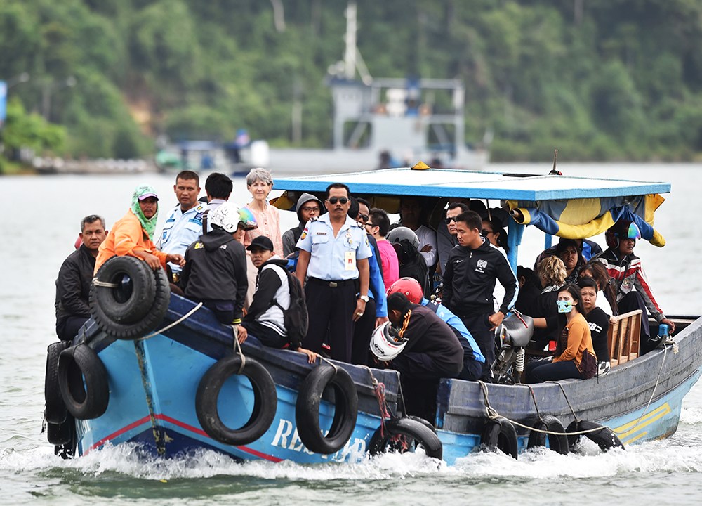 Cônsule geral australianos e família dos condenados à morte na Indonésia por tráfico de drogas, Andrew Chan e Myuran Sukumaran, seguem de barco após visita na prisão da ilha Nusakambangan