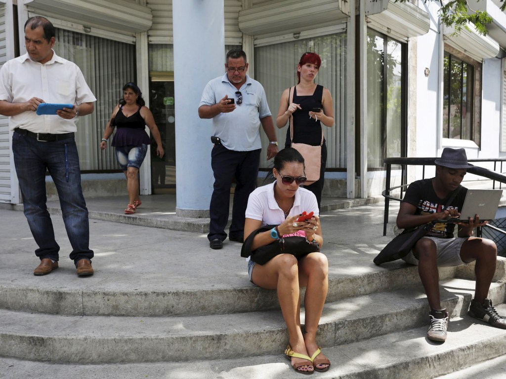Cubanos usam a internet em uma via pública de Havana. Cuba abriu 35 pontos de acesso Wi-Fi em todo o país, oferecendo acesso sem precedentes
