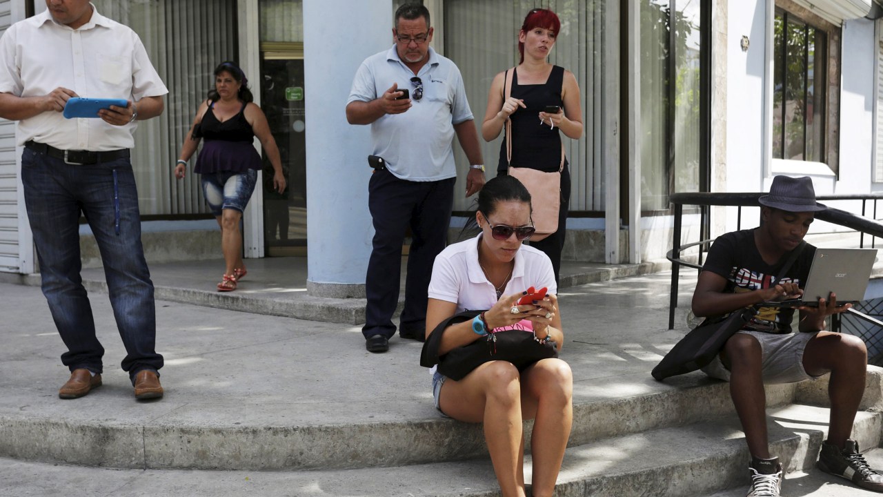 Cubanos usam a internet em uma via pública de Havana. Cuba abriu 35 pontos de acesso Wi-Fi em todo o país, oferecendo acesso sem precedentes