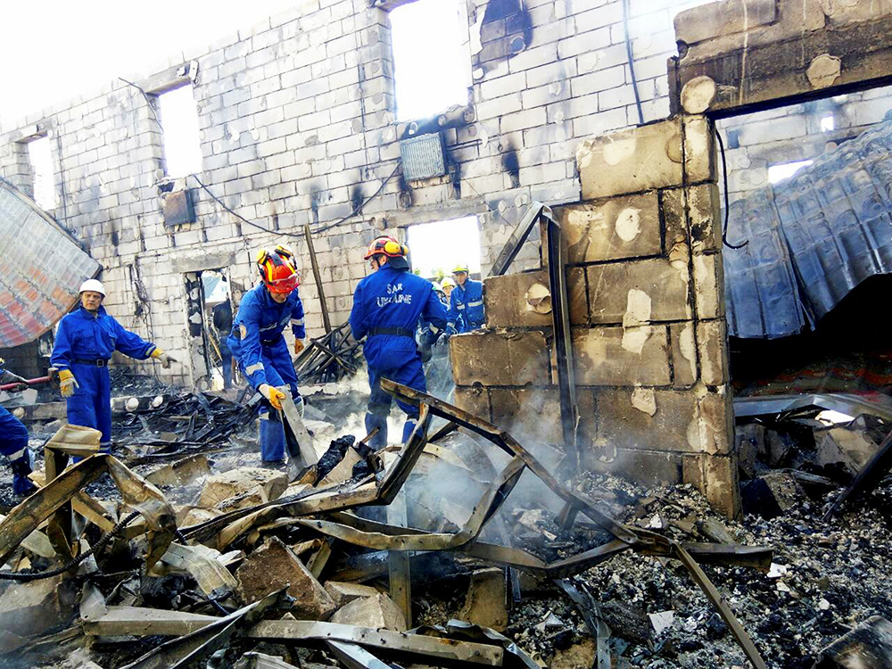 Equipes de resgate vasculham escombros, após um incêndio matar 17 pessoas em um asilo, na aldeia de Litochky, próximo à Kiev, na Ucrânia - 29/05/2016