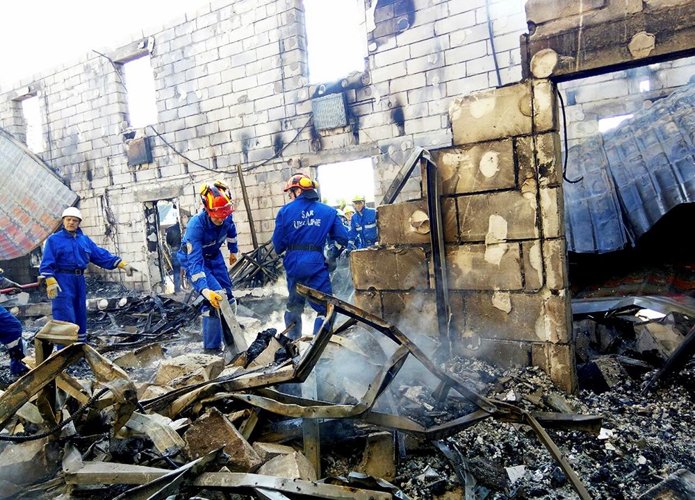 Equipes de resgate vasculham escombros, após um incêndio matar 17 pessoas em um asilo, na aldeia de Litochky, próximo à Kiev, na Ucrânia - 29/05/2016