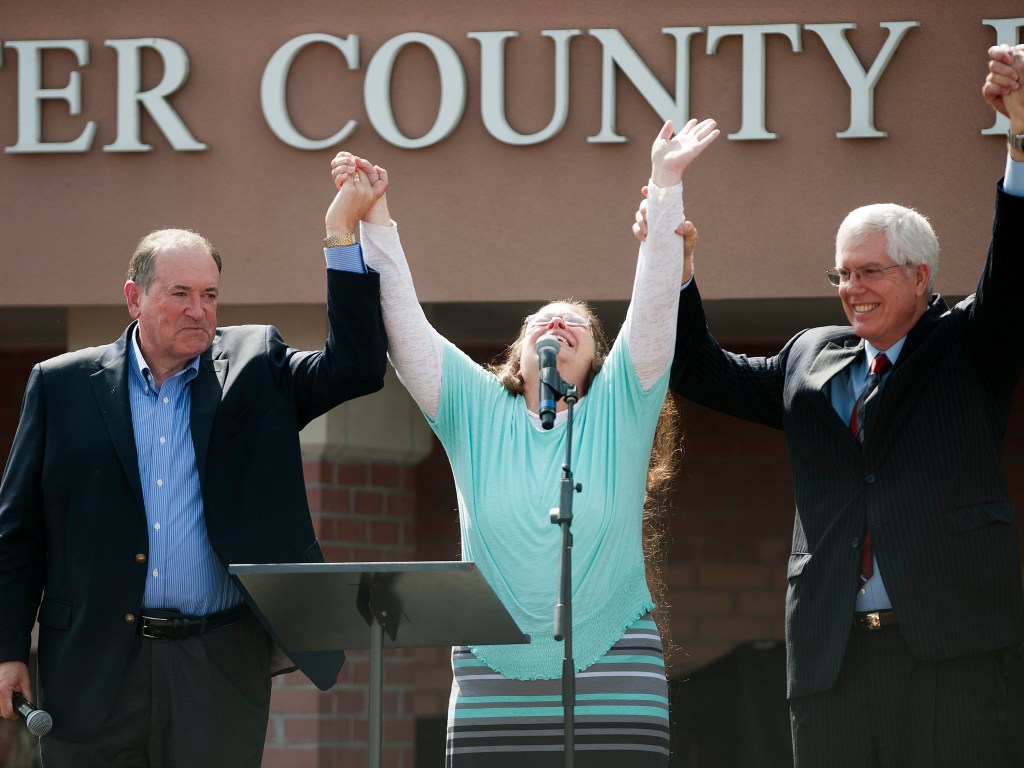 Kim Davis segura as mãos de seu advogado Mat Staver (à dir.) e do candidato republicano Mike Huckabee em frente ao Centro de Detenção de Grayson, Kentucky - 08/09/2015