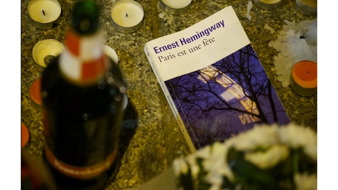 Exemplar do romance 'Paris É Uma Festa' do escritor norte- americano Ernest Hemingway visto entre as homenagens às vítimas dos atentados na capital francesa
