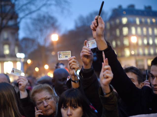 Jornalistas levantam seus cartões de imprensa e canetas, durante manifestação na Place de la Republique (Praça da República), em Paris - 07/01/2015