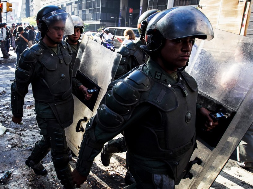 Membros da Polícia Nacional Bolivariana retiram barricadas durante manifestação pelo aniversário da prisão do líder da oposição Leopoldo López em Caracas - 18/02/2015