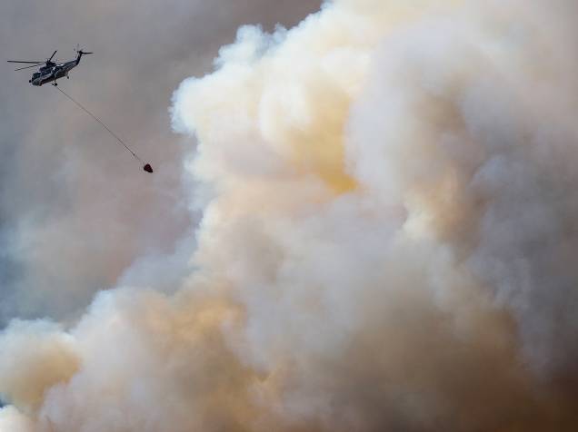 Helicóptero sobrevoa fumaça provocada pelo incêndio florestal, que atingiu às proximidades da cidade de Fort McMurray, no Canadá. Todos os moradores de cidade foram evacuados da região - 04/05/2016