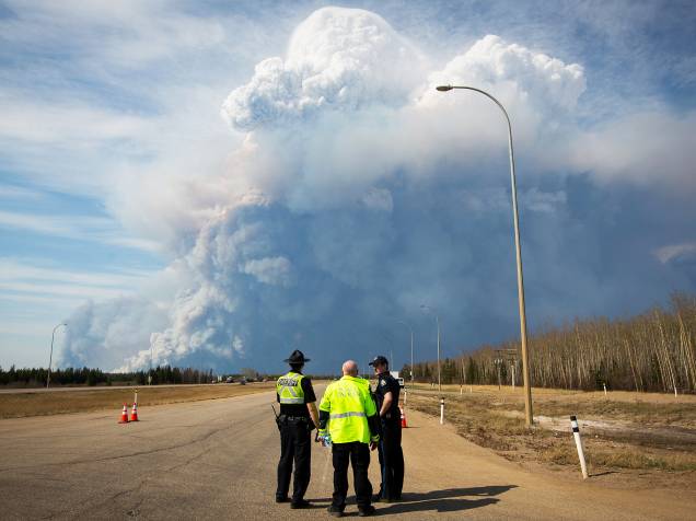 Policiais observam coluna de fumaça, provocada pelo incêndio florestal que atingiu a cidade de Fort McMurray, no Canadá. Mais de 80 mil pessoas foram evacuadas do local - 04/05/2016
