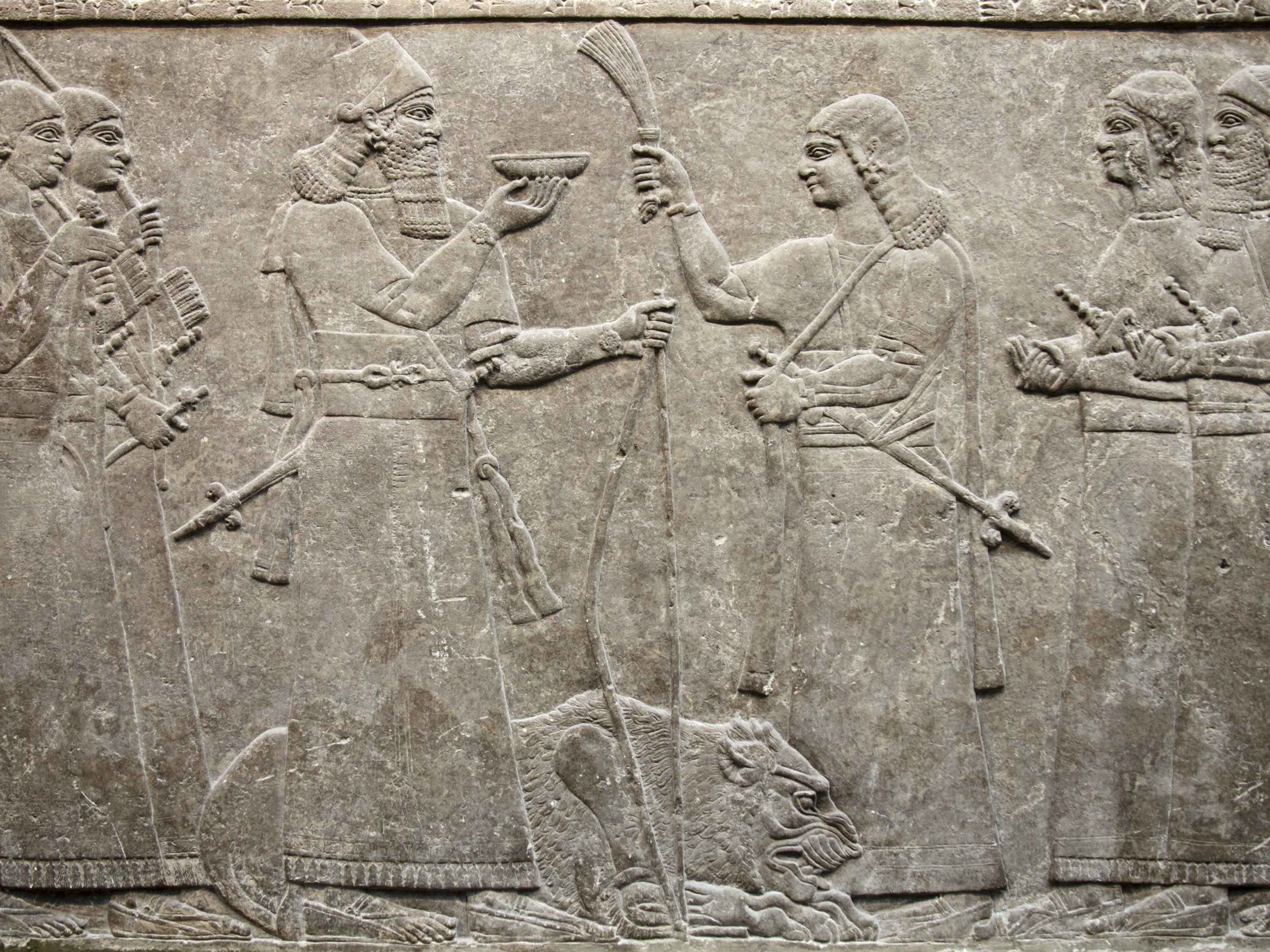 Relevo antigo Assírio 865-860 a.C de Nimrud que mostra o rei Ashurnasirpal acompanhado por seus cortesãos oferecendo um leão em sacrifício