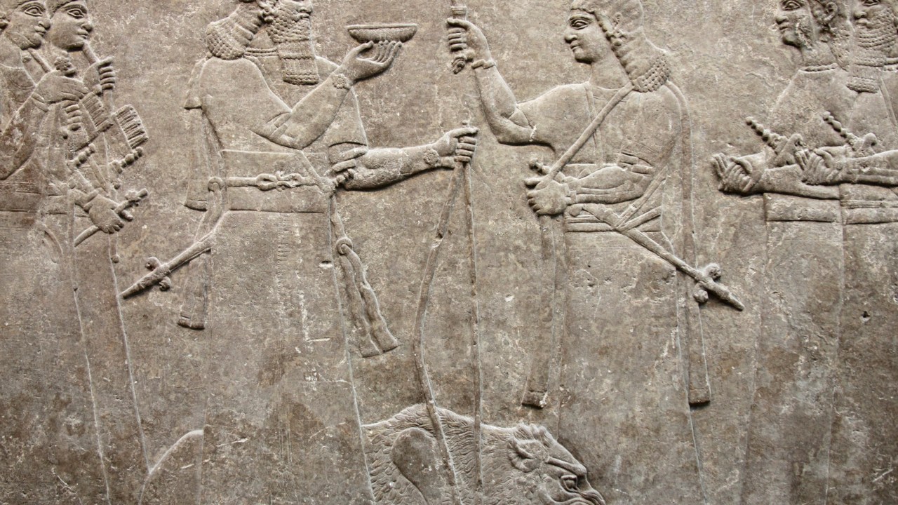 Relevo antigo Assírio 865-860 a.C de Nimrud que mostra o rei Ashurnasirpal acompanhado por seus cortesãos oferecendo um leão em sacrifício