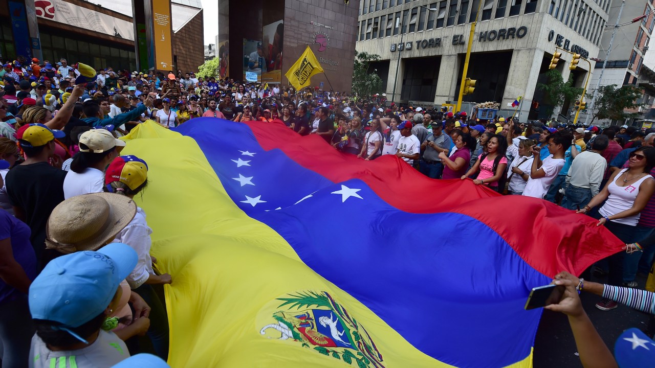 Manifestantes oposicionistas carregam uma bandeira da Venezuela em apoio aos deputados recém-eleitos em frente à Assembleia Nacional, em Caracas - 05/01/2016