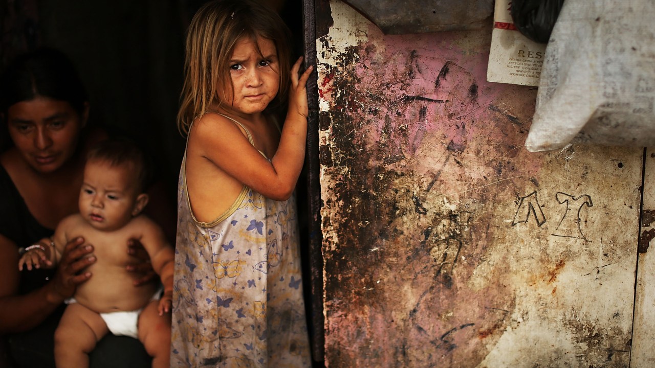 Menina fotografada no barraco onde mora com sua família na periferia de Tegucigalpa, em Honduras