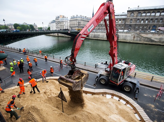 Trabalhadores criam uma praia artificial temporária ao longo do Rio Sena, em Paris em preparação à 14ª edição do Paris Plages, iniciativa que transforma pontos da capital francesa em pequenas praias durante o verão com atividades para turistas e moradores