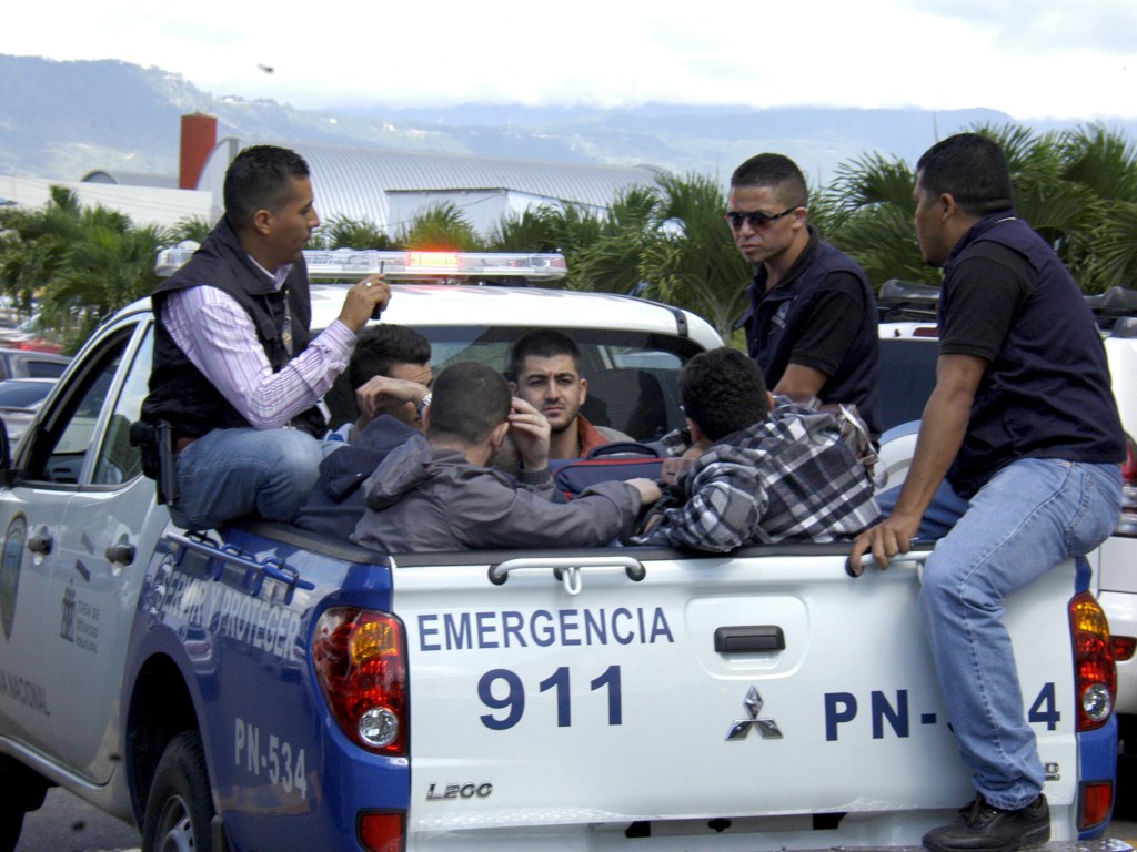 Policiais escoltam cinco homens sírios detidos no aeroporto internacional de Toncontin em Tegucigalpa, Honduras - 18/11/2015